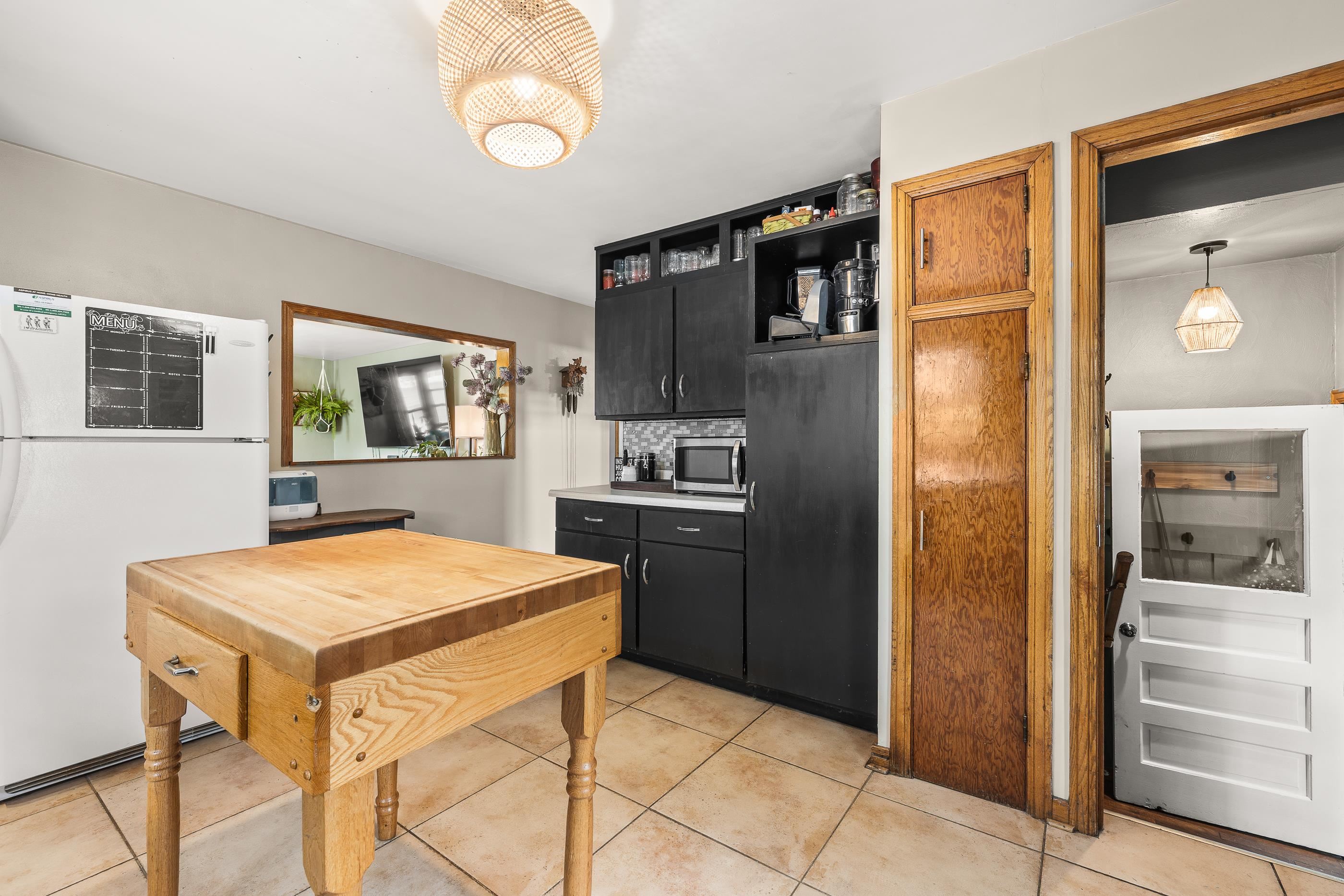 View in kitchen to living room. There is an interior window opening from kitchen to living room.