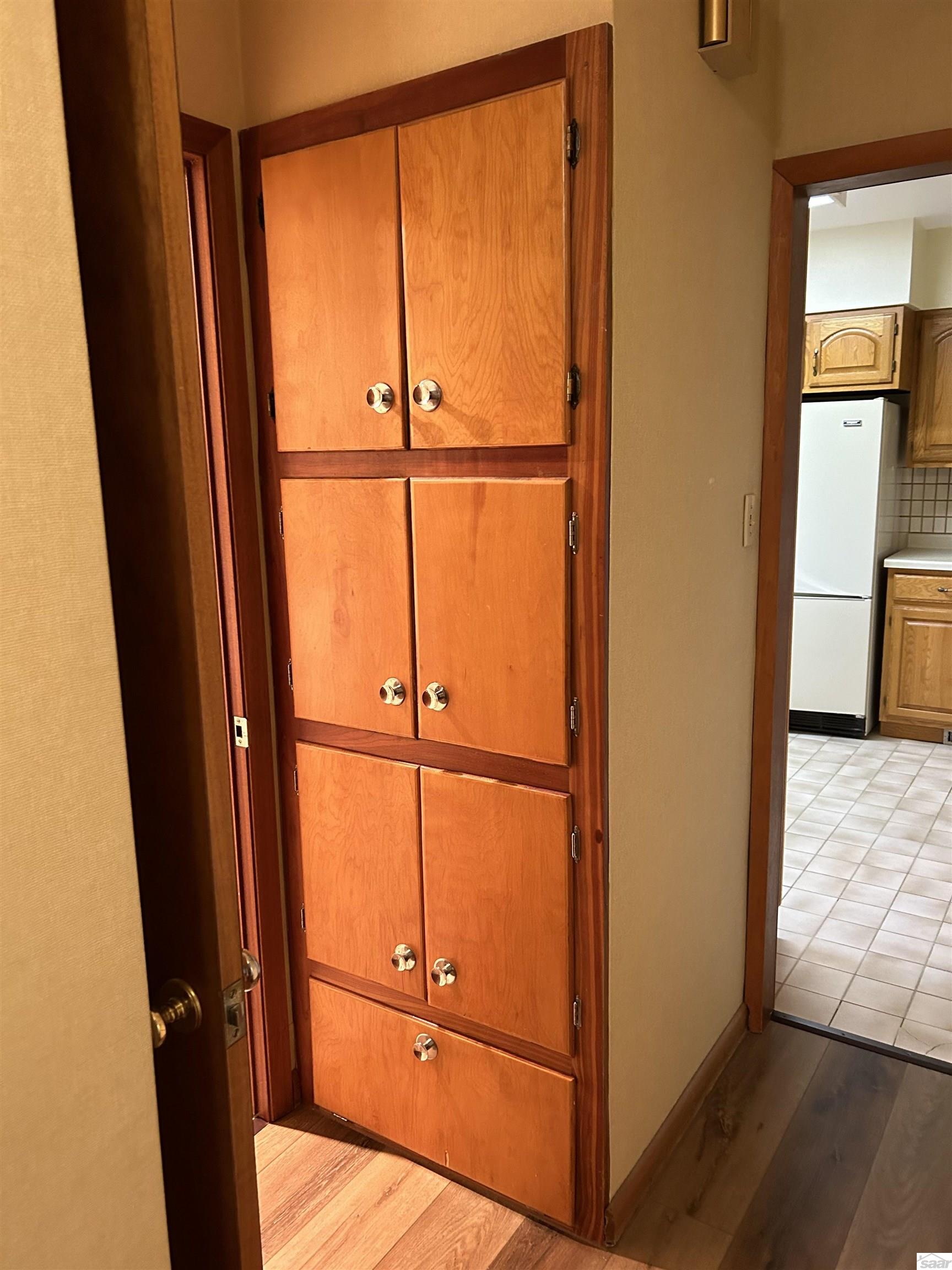 Room details with white refrigerator, light hardwood / wood-style floors, and tasteful backsplash