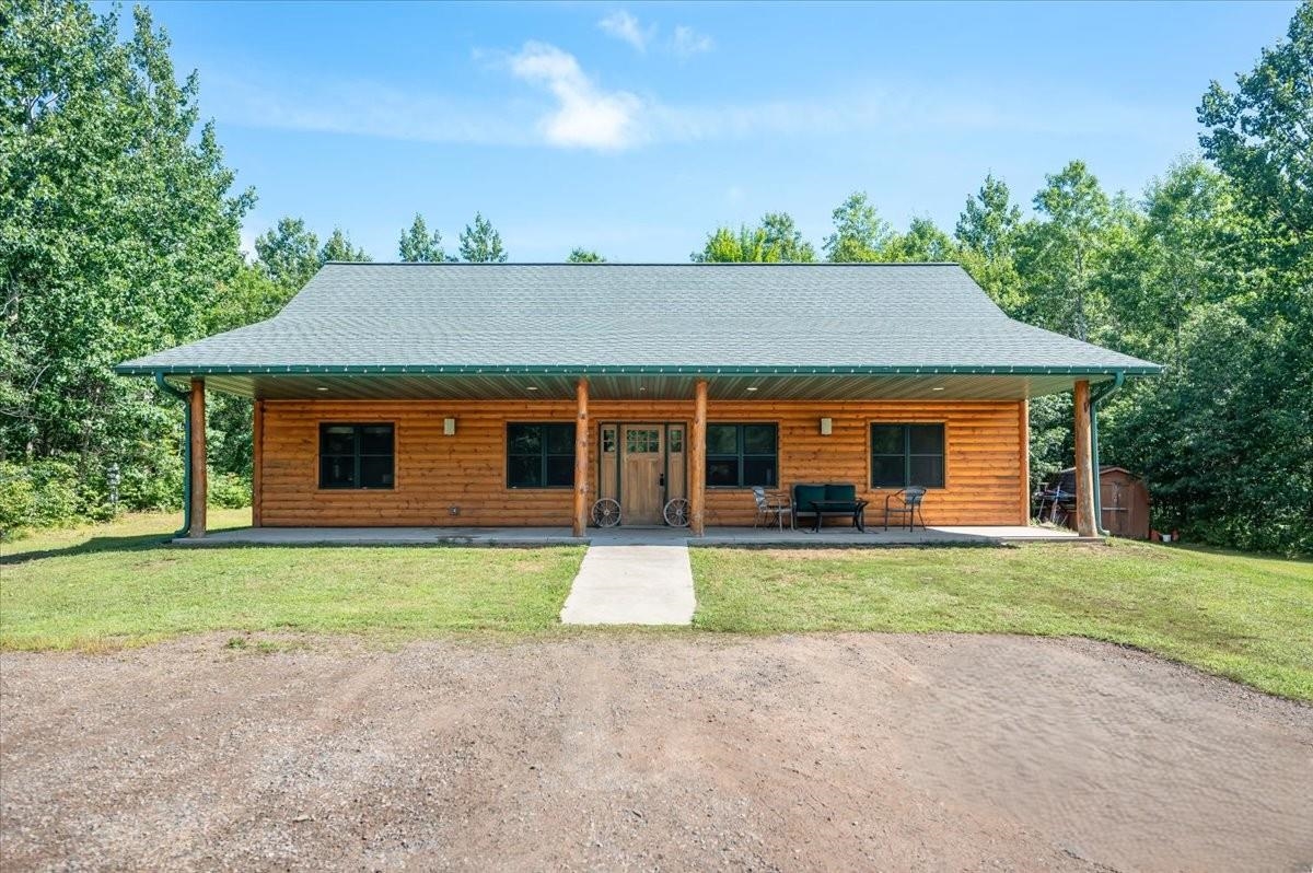 Northwoods retreat for every season, tucked away in a quiet, secluded setting just 10 minutes from Iron River. This energy-efficient three-bedroom, two-bath one-level Ranch home sits on 20 acres and is surrounded by hundreds of acres of Bayfield County land. This property is perfect for outdoor enthusiasts, with private trails, an open hunting area, and a hunting stand that is included with the property. You can directly access Bayfield County’s extensive network of ATV/snowmobile trails and forest roads from your driveway—no need to trailer your machines! Working from home is easy with Norvado's high-speed fiber optic internet, offering packages from 100 MB up to 1 GB. The home boasts nine-foot ceilings, solid wood doors, in-floor radiant heat, and an inviting open-concept design. The spacious great room features a fireplace, laminate flooring, and a ceiling fan, opening to the kitchen and dining area. The kitchen is equipped with stainless steel appliances (refrigerator, microwave, stove, dishwasher), custom maple cabinetry with pull-out shelving, a breakfast bar, portable island/desk, and ample counter space for family gatherings or entertainment. A patio door leads to the backyard, while both front and back poured-concrete porches offer covered outdoor spaces for grilling outside and patio furniture. A swimming pool for summer enjoyment is also included. The primary suite includes a walk-in closet and a primary bathroom with a double-sink vanity, a jetted whirlpool corner tub, a separate shower, and a vent fan light. Two additional bedrooms feature laminate floors, ceiling fans, and abundant natural light, with a full bathroom conveniently located between them. A large utility room provides a washer, electric dryer, washtub, and floor drain. Geothermal, in-floor radiant heating system, on/off peak electric system with two 200-amp panels, and LED lighting throughout. This home is built on a poured concrete slab with Geothermal in-floor heat, an air exchanger, half-log siding, wood frames, double-pane windows, and an asphalt roof.  Hunter's Paradise or Nature Lovers Retreat!  Explore private trails lined with wild blueberries and wildflowers, leading to a peaceful open area with a deer stand—perfect for viewing wildlife or hunting game. Families with children will enjoy nature right outside their door, and it is located in the Maple School District.