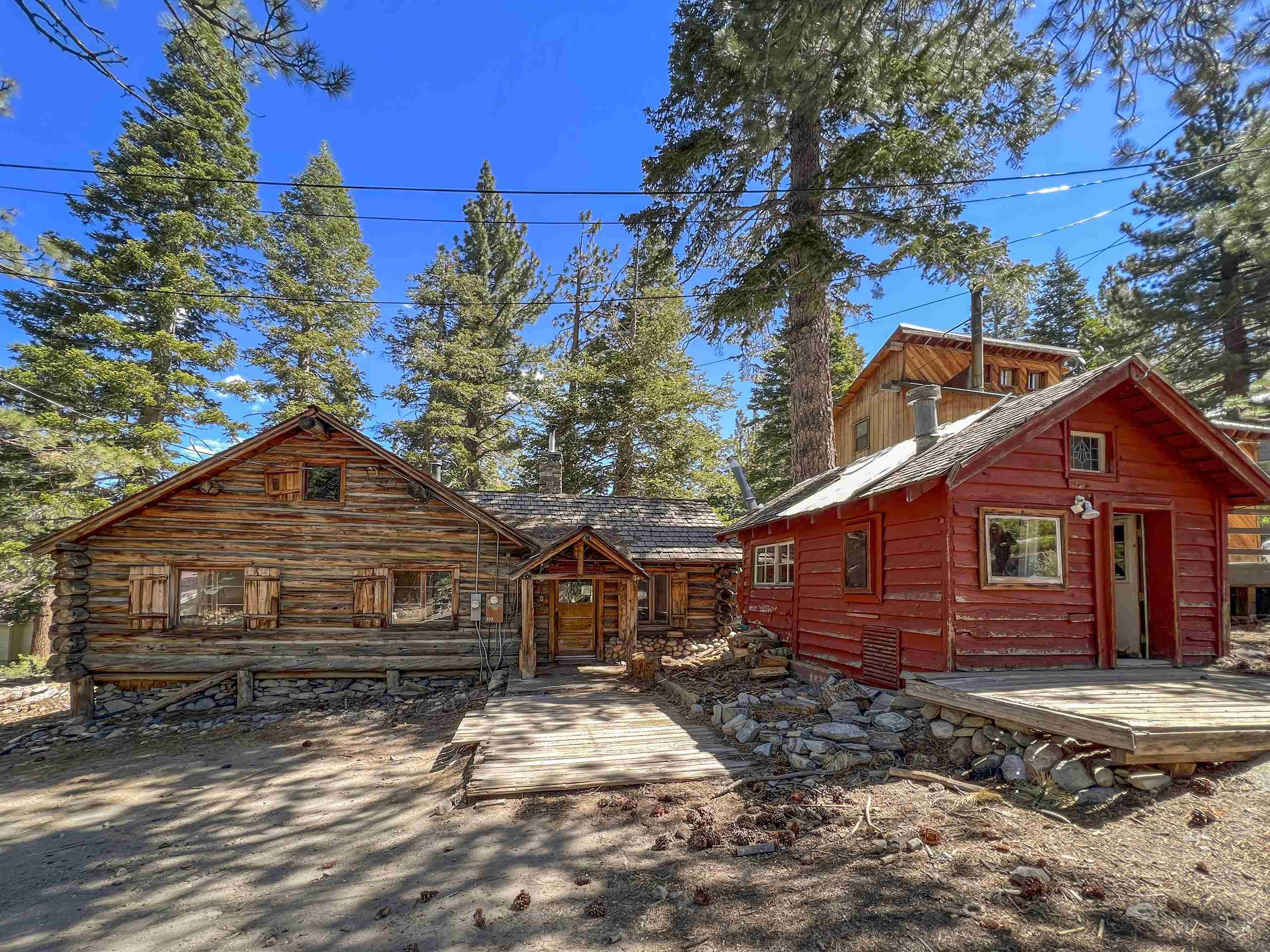 Charming Cabin in Old Mammoth! On this half-acre parcel you will find TWO homes. The first, “The Robinson Cabin”, is an original log cabin from the late 1920s and is approximately 1196 sq. ft. This one-bedroom plus loft and one-bath cabin has so much history, it served as the community center of the Mammoth Camp area in the 1950s and features a faded shuffleboard court and checkerboard painted on the floor. There are paintings from the 1930s on the ceiling and carvings throughout. The history here goes on and on! The second medium-sized structure is a two-bedroom one-bathroom house built in the 1980s and is approximately 656 Sq. ft. This home features a kitchen and balcony with gorgeous views of the Sherwin Range. The smallest structure on the property is currently a storage shed. The possibilities here are endless. This is the perfect opportunity for someone to live in one house and rent the other. Or, start from scratch and build your dream home on this secluded part of town. This property is sold in AS-IS condition.