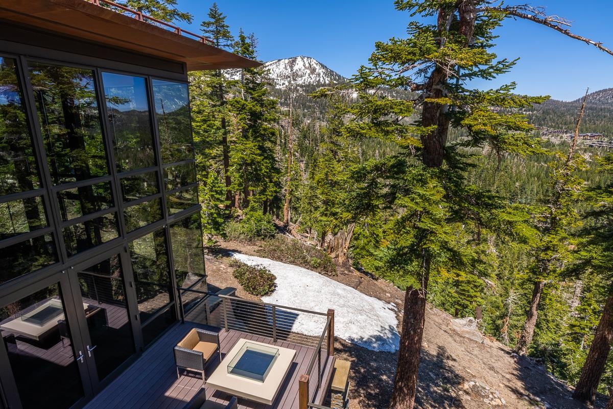 Take a walk in the clouds from the comfort of your living room in this custom designed 4000’ sq. foot modern architectural home. Located in the coveted Bluffs neighborhood, this chic departure from the more traditional mountain style home, with its steel beams, floor to ceiling windows, and panoramic views of Mammoth Mountain, the Town of Mammoth Lakes, and the epic Eastern Sierras, is an enticing option for those looking for an elegant alternative to the rustic cabin experience. Minutes to Eagle Lodge and the Lakes Basin, it’s a sportsman’s paradise in an unparalleled location. Enjoy star filled evenings beside the outdoor gas fireplace with one of the most majestic views in the Sierras, or relax in the hot tub on cold winter nights. This multi-level property comes partially furnished, and the expansive walls are a perfect place to display your art collection. The builder had an eye for detail, bringing nature into the home by incorporating a massive boulder into the living room in this Frank Lloyd Wright inspired design. With 3 bedrooms plus a loft, 3.5 bathrooms, and 3 fireplaces, there are endless environments to spread out and relax in. The primary bedroom suite will make you feel like you are sleeping in the forest with its own private deck, sweeping views, private fireplace, and spacious bathroom with an immense steam shower. Downstairs can be used as a separate suite with 2 bedrooms and baths, one with a steam shower, the other including a jacuzzi tub. It also features a den, office, fireplace, and kitchenette.  A heated garage completes the property with extensive storage and loads of built-ins for all your outdoor sports gear. Don’t miss out on this rare opportunity to own a mountain modern home in a stunning natural environment that inspires awe in everyone who sees it!