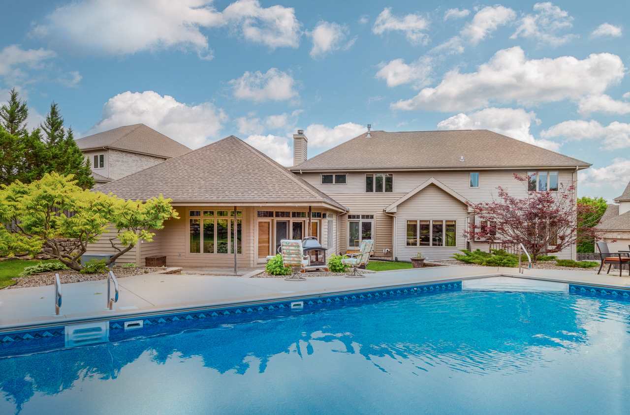This beautiful home has abundant space & understated luxury. The formal combined living room + dining room are great for entertaining. A sunny, spacious kitchen w/breakfast bar & Canadian Maple cabinets flows into both the sunroom which leads to the deck overlooking the pool, and the family room with fireplace. Complete in-law suite/Cabana room with large tiled sitting area, high-end Birch kitchen, private bedroom, laundry + bath. Upper level has a convenient 2nd laundry that opens to owner's suite with gas fireplace and huge closet. A great lower level features a rec room with fun bar, exercise room, full bath & bedroom. Fenced yard, in-ground pool, 3+ car garage. UHP warranty included.