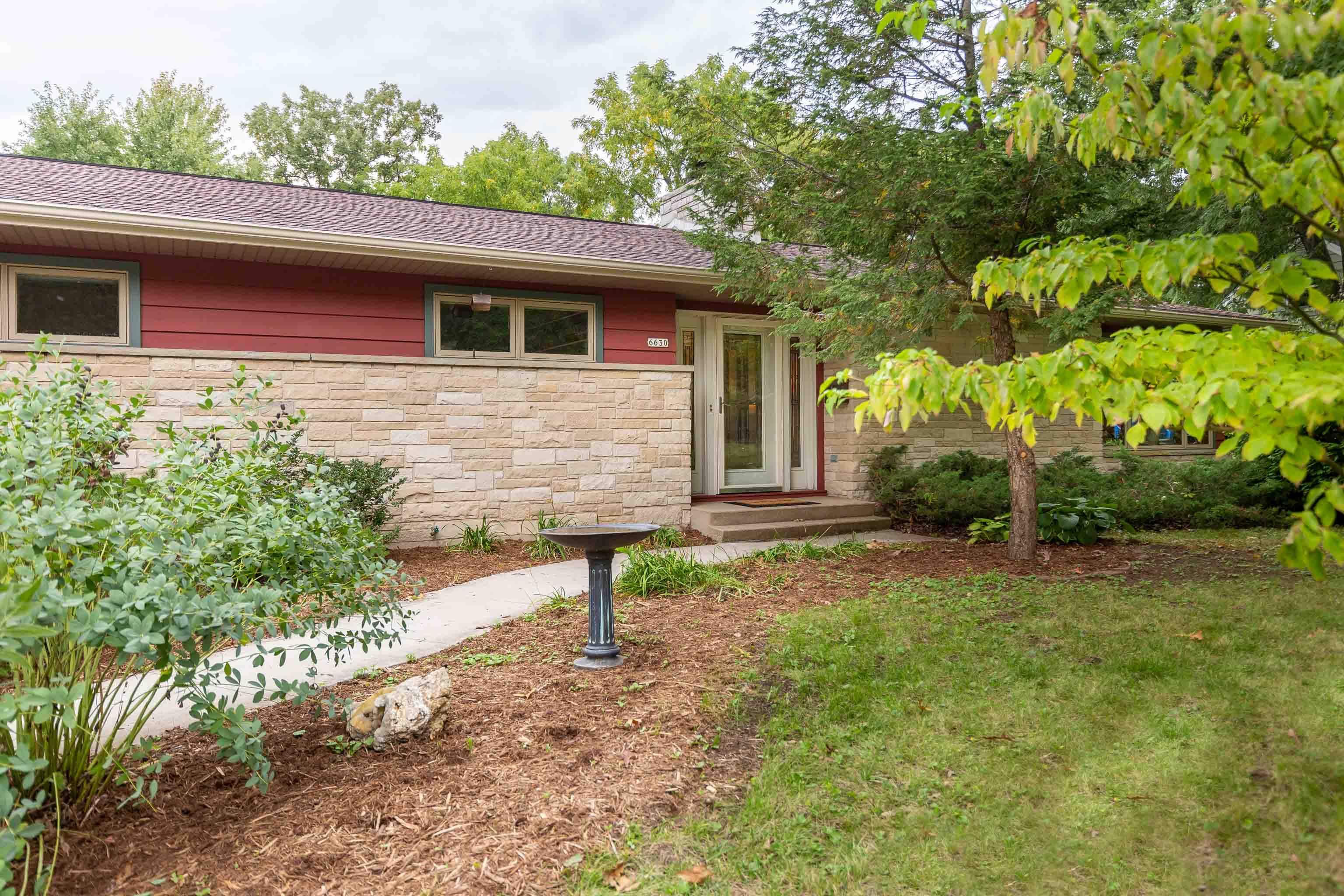 This sprawling, midcentury modern ranch sits on a lush, private, wooded lot in Middleton, walking distance to downtown shops + dining, schools, Lake Mendota & parks. As if that's not enough, the eco-friendly home has been lovingly maintained & thoughtfully updated to suit the architecture. A stunning kitchen takes center stage w/beautiful, custom maple cabinetry + lots of counter space. Just off the kitchen are a serene sunroom that opens to the deck, a big laundry room + a dining room. Enjoy a cozy fire in the spacious living room that wows with an offset lannon stone surround fireplace & big windows. The 3 bedrooms feature the original wood flooring that's throughout the main level. A big LL includes a rec room with bar, a fireplace, an office, a bonus room + full bath.