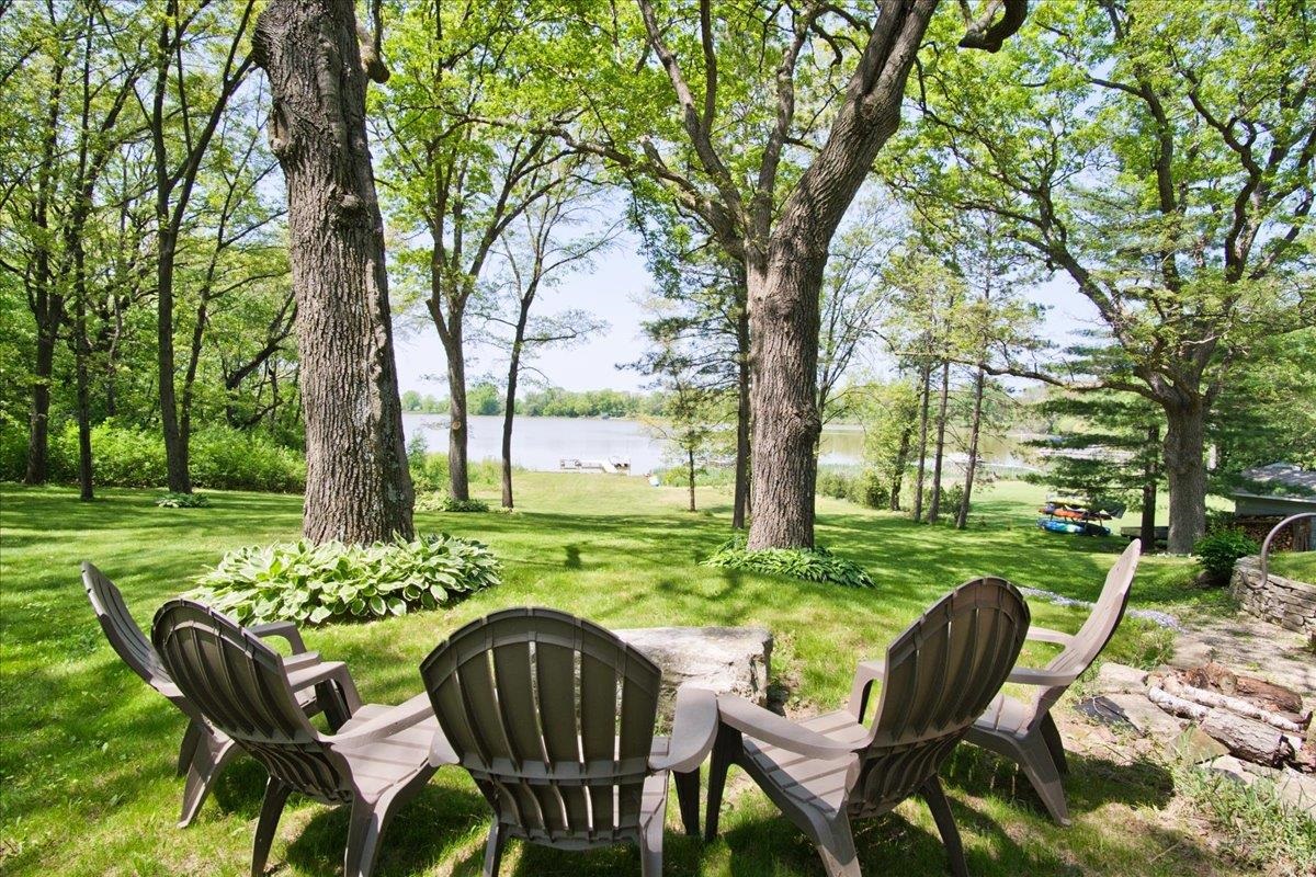 Wake to the peace and tranquility of lake living just minutes from Stoughton in this wonderful walkout ranch with 73' of frontage on Bass Lake. The wall of windows in the large great room greet you as you enter this delightful & warm home surrounded in natural wood interior accents, gorgeous birch floors & nature all around you on this acre+ lot with stunning mature trees! The chef will love the kitchen which boasts tons of cherry cabinets & great workspace, including pantry, all meticulously designed!  Three good sized bedrooms on ML. The walkout LL has 2 huge rec rooms for all the fun you can imagine! Warm up by the cozy wood stove & make this your favorite theater room! The lake front & huge yard are spectacular! Water ski, sail, boat, fish, bird watch,  & relax by the fire pit - Enjoy!