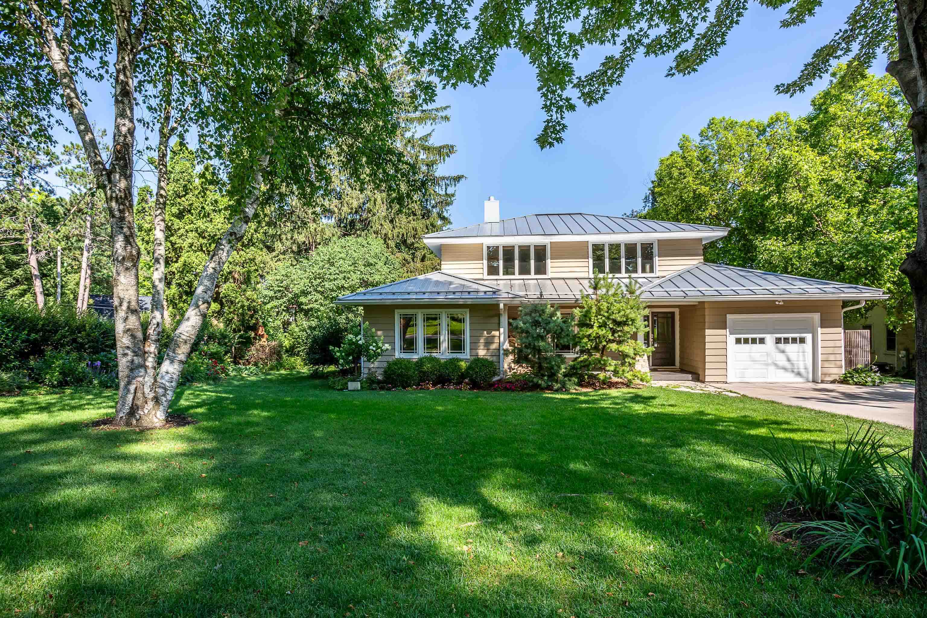 This stunning Shorewood Hills home perfectly blends classic architecture with modern organic touches that elevate the space creating a warm & inviting home. Walls of windows & glass doors to the expansive composite deck overlooking the lush landscape add an additional layer of beauty with indoor/outdoor appeal. The open layout of the main floor features a living room with a wood burning fireplace that can also be enjoyed from the large dining room. The bright & airy kitchen leads to a partially finished lower level with a workshop + loads of opportunity for expansion. There are 4 generously sized bedrooms with wood floors & 2 remodeled modern bathrooms with luxury hotel vibes. Great location close to the UW, the hospitals + all Shorewood amenities.
