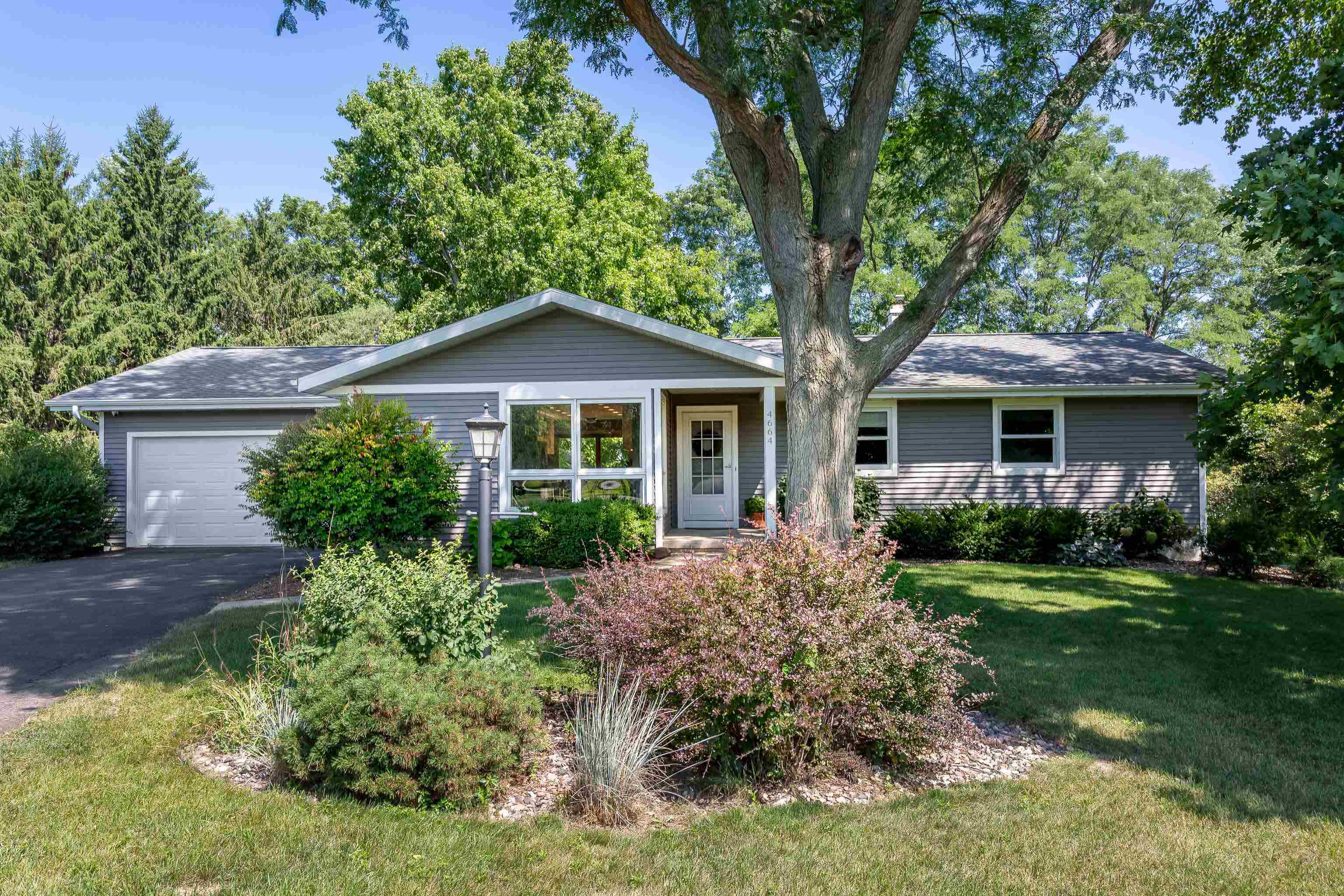 Beautiful Middleton home on a private, wooded lot with a large, fenced-in yard on a cul-de-sac. Want to enjoy beautiful summer evenings on your expansive deck overlooking a lush, verdant backyard, cozy up in front of the fireplace on chilly winter nights, host Thanksgiving in your spacious and inviting dining room, invite friends over for game night in the huge lower-level rec room with kitchenette, or set-up a private home office in the bonus room? This house can do all that and more. You'll also love the bright and airy modern kitchen, the convenience of main-level bedrooms, including a primary suite with heated floors and an artfully tiled shower, a huge laundry room, and the convenient location close to parks, shops, and restaurants. Welcome home!